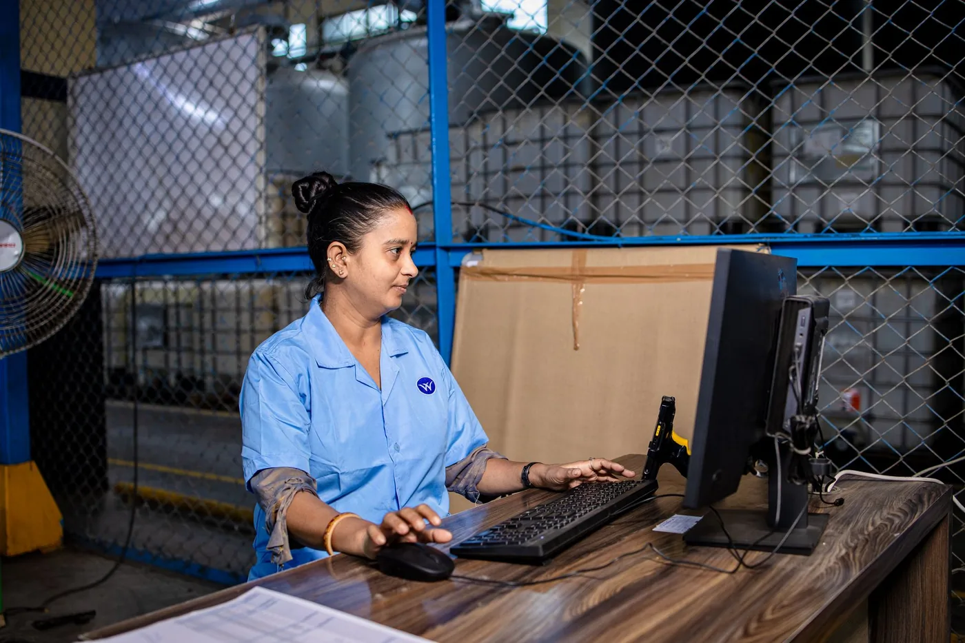 Factory worker using a computer on an industrial floor