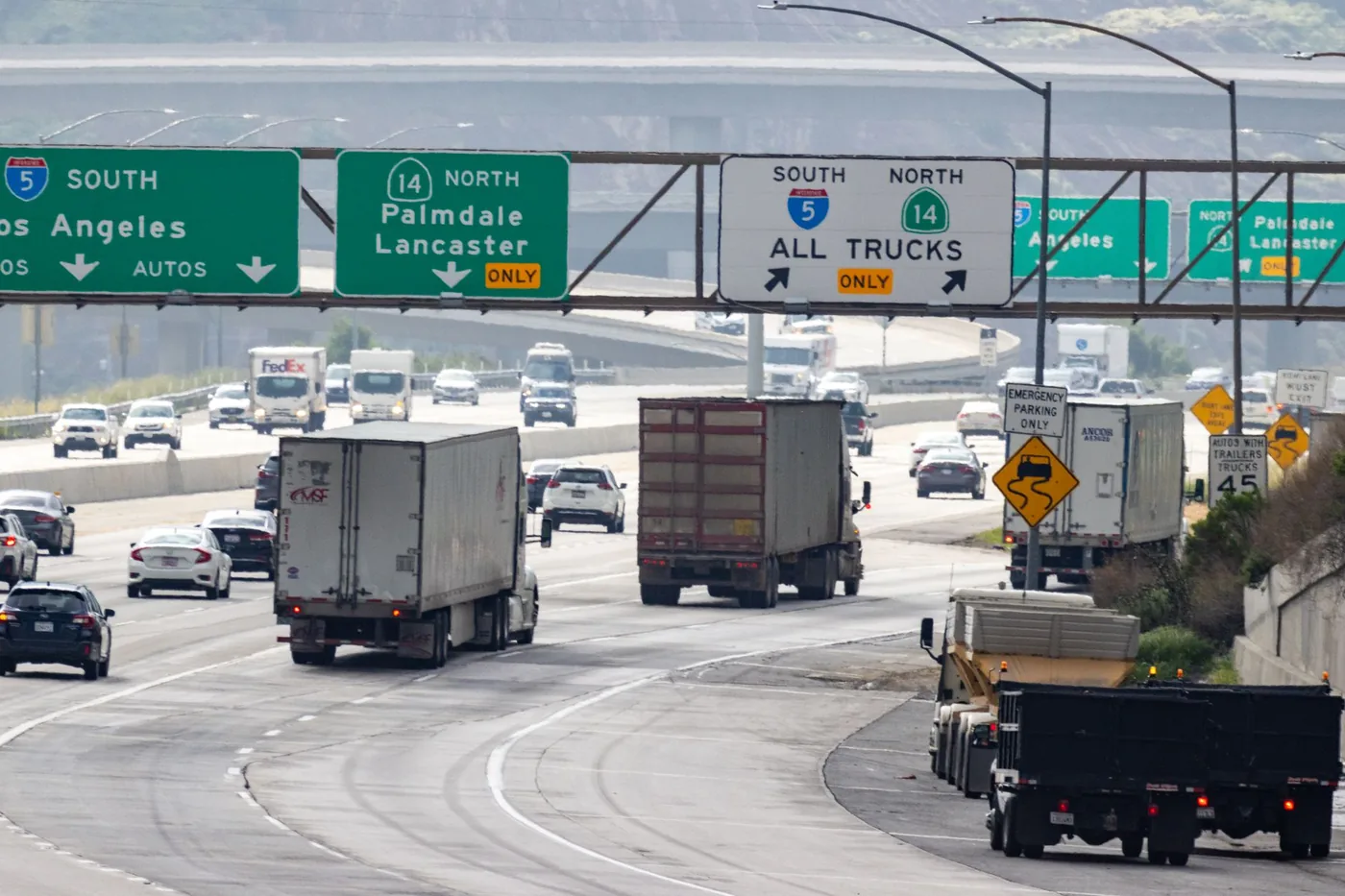 Traffic with trucks and cars on a highway in California heading to Los Angeles.