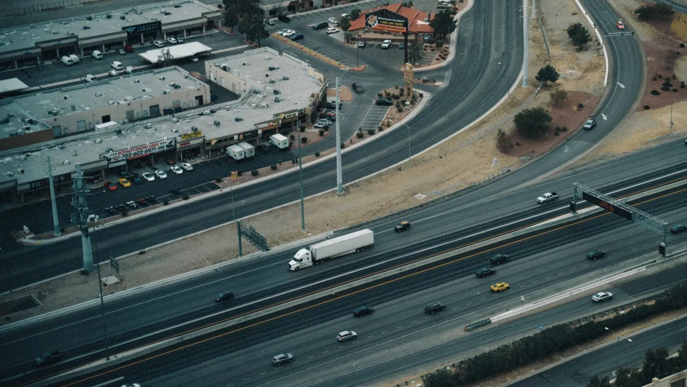 Aerial shot of a highway in Las Vegas showing traffic and nearby commercial area.