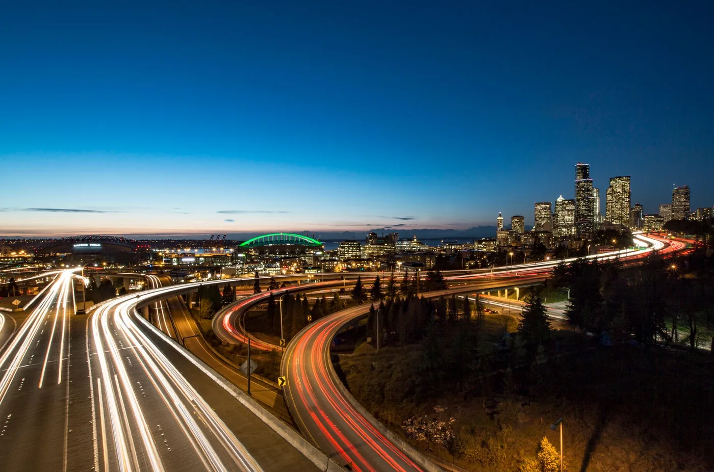 Stunning city skyline at dusk featuring vibrant light trails and a scenic urban landscape.