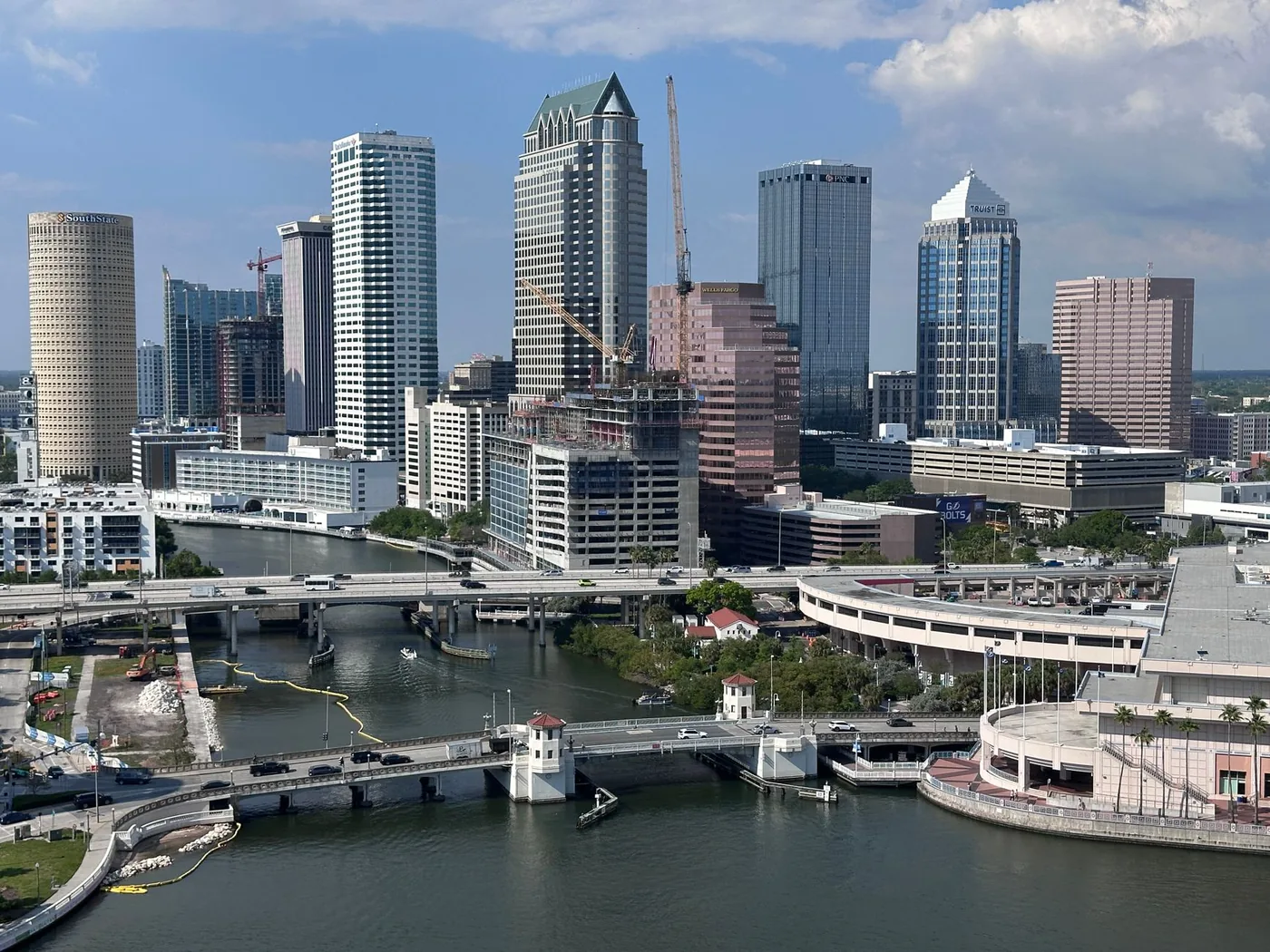 Aerial view of the vibrant Tampa skyline with high-rise buildings and serene river flowing below.