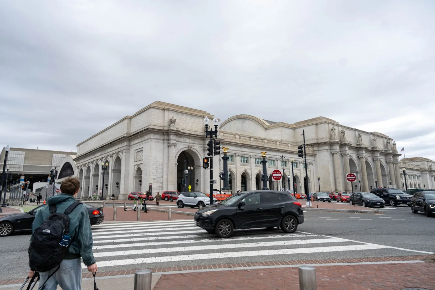 Union Station in Washington D.C. bustling with pedestrians and cars on a cloudy day.