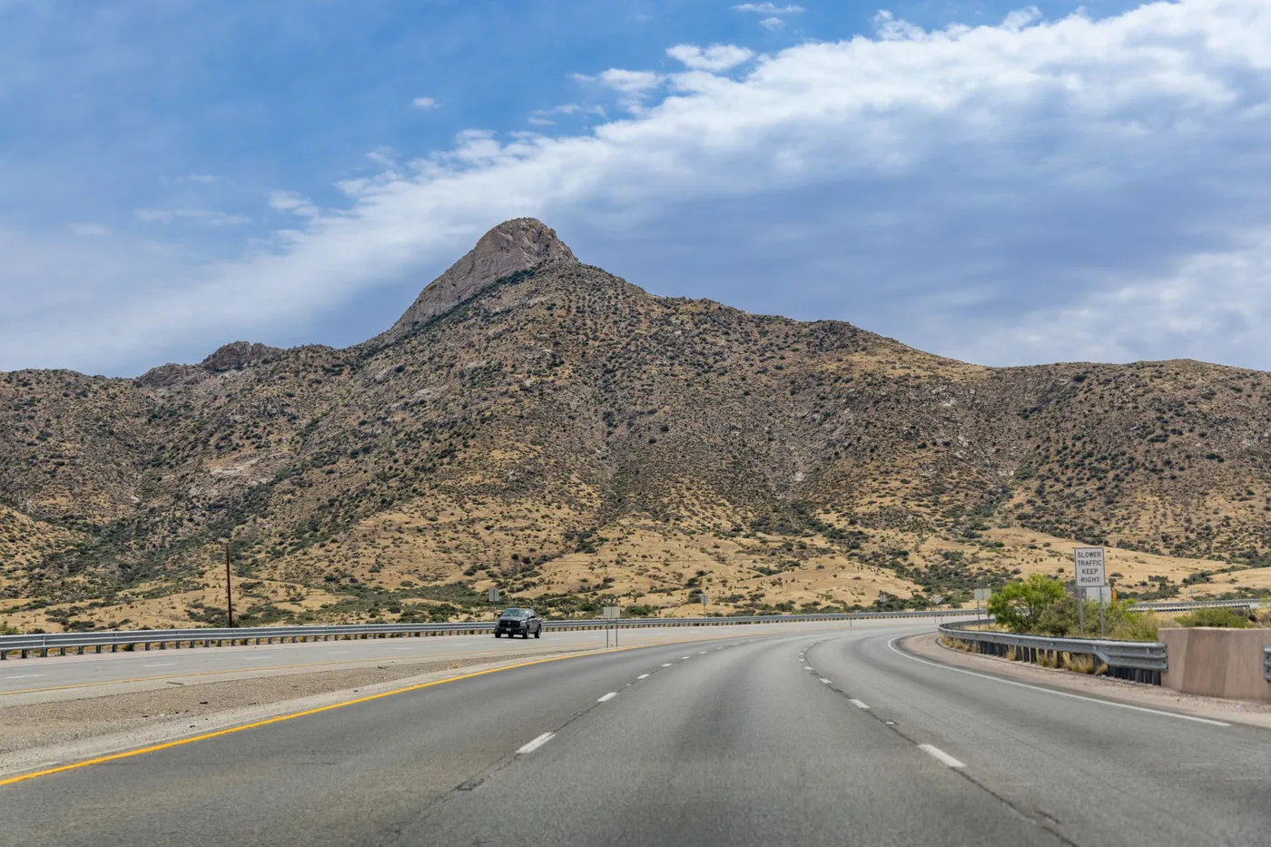 Desert highway leading to rugged hills under a clear sky in El Paso, Texas.