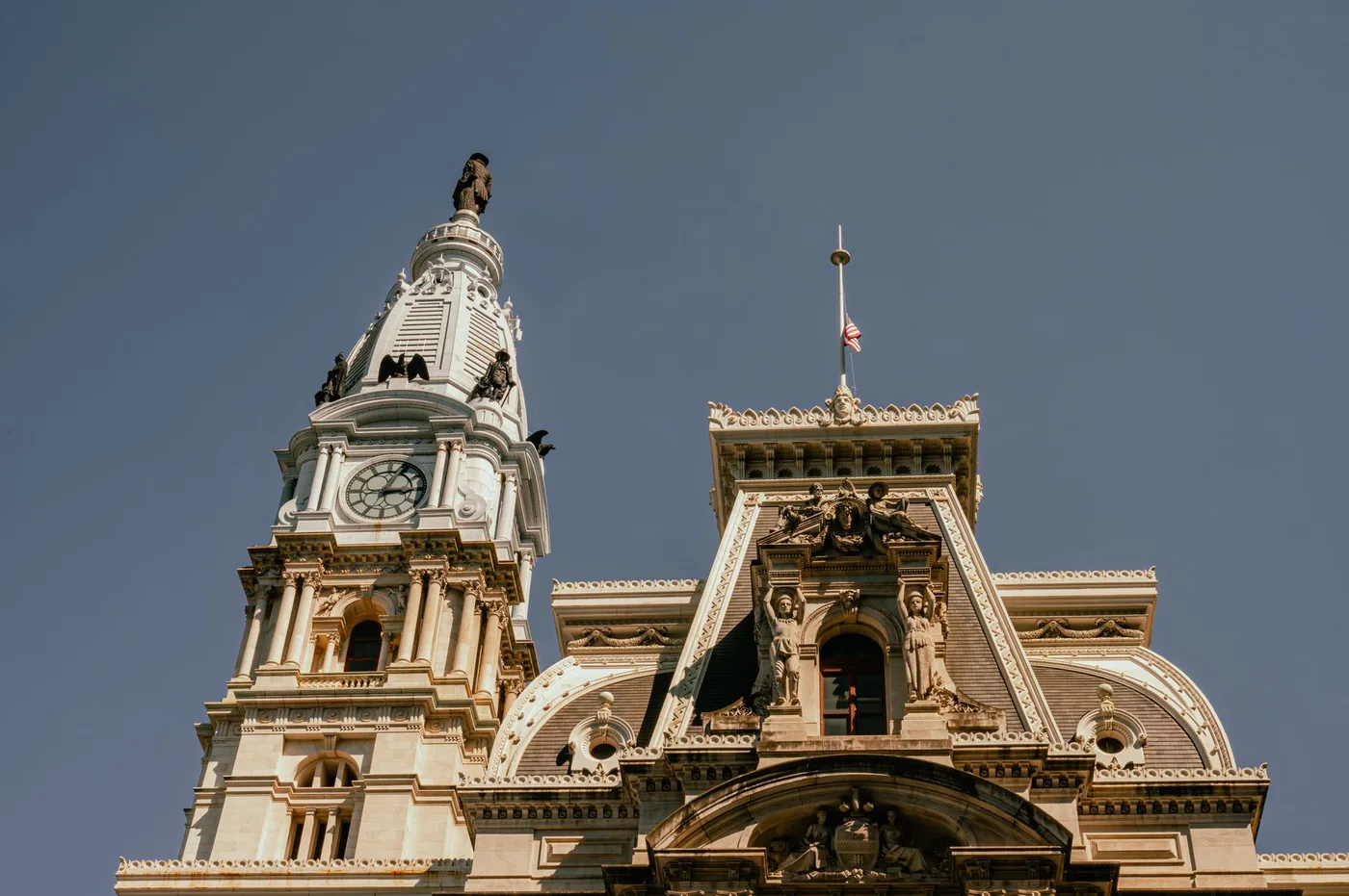 Close-up perspective of the iconic Philadelphia City Hall with its grand clock tower against a clear sky.