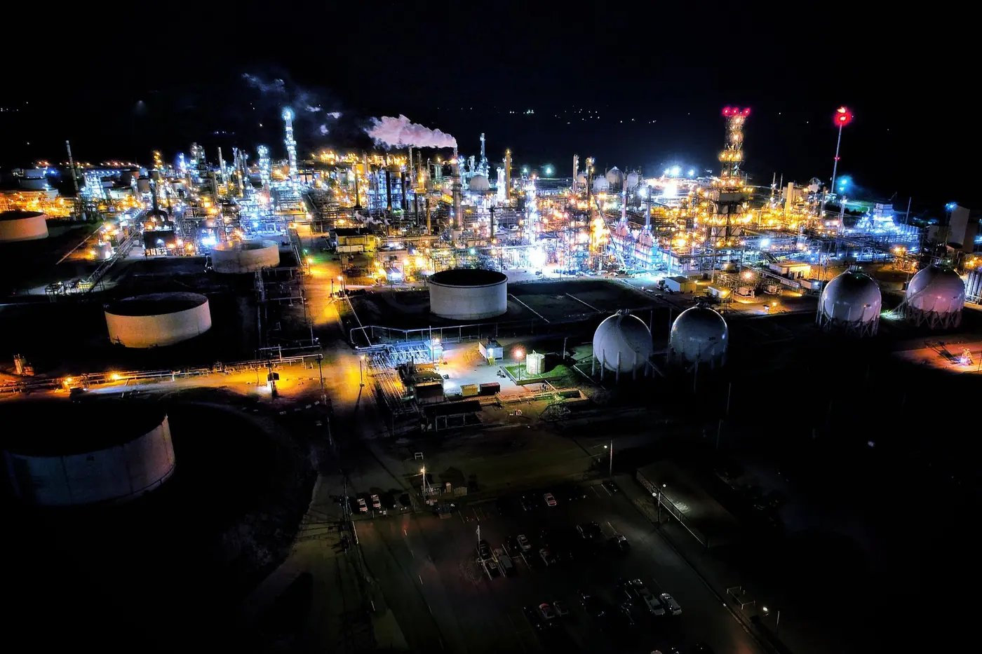 Aerial view of a refinery lit up at night, the kind of 24/7 plant that runs a DuPont rotation