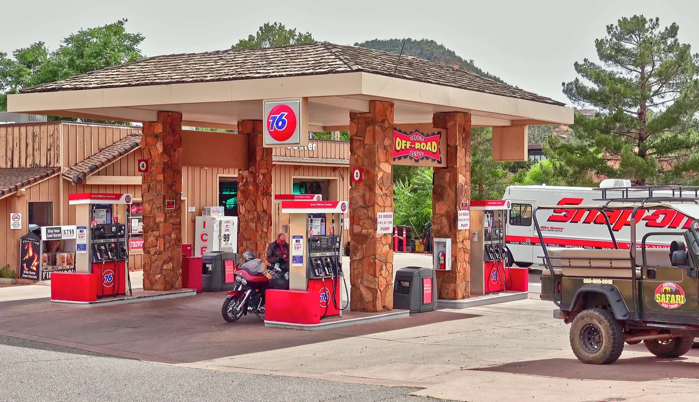 A scenic gas station in Sedona, AZ with a motorbike and vehicles nearby, capturing the essence of travel and refueling.