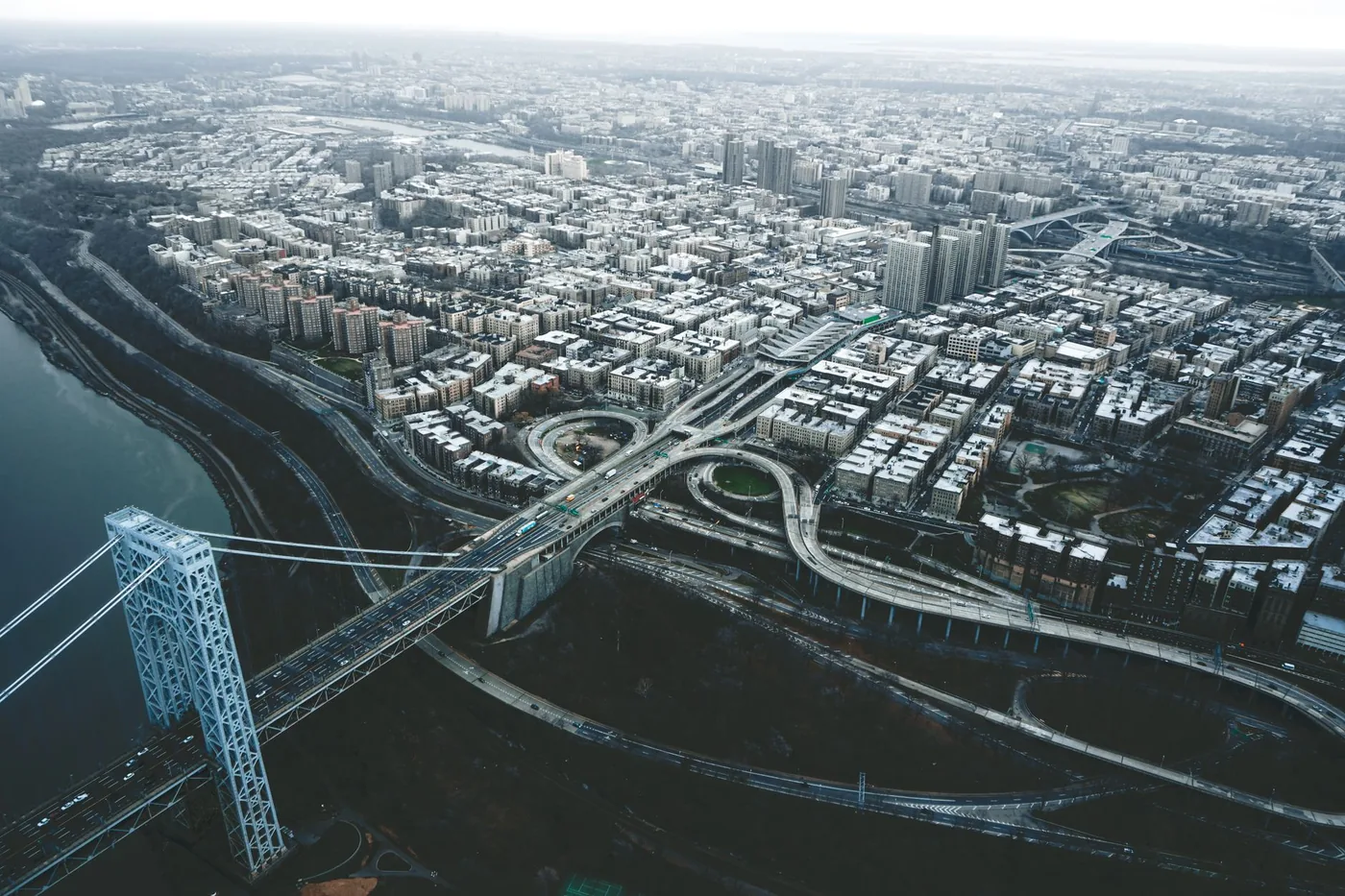 Drone view of George Washington Bridge crossing river and connecting districts of New York City against cloudy sky