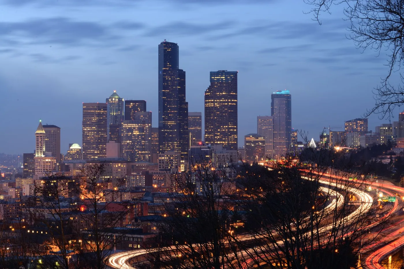 Stunning view of the illuminated Seattle skyline at night with dynamic light trails on highways.