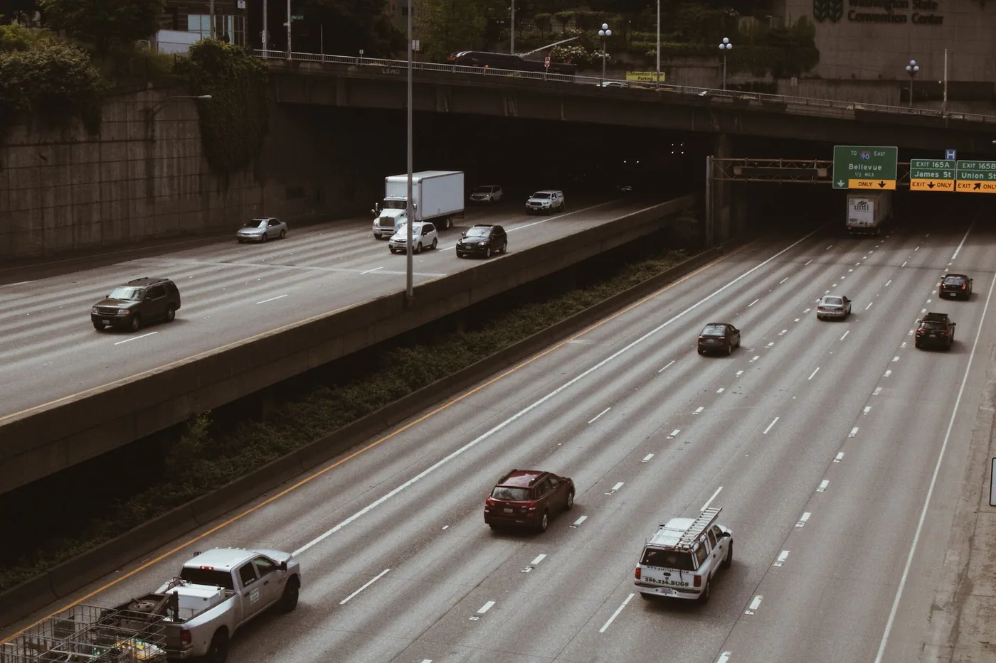 Cars and trucks on a highway in Seattle with visible signage and overpass.