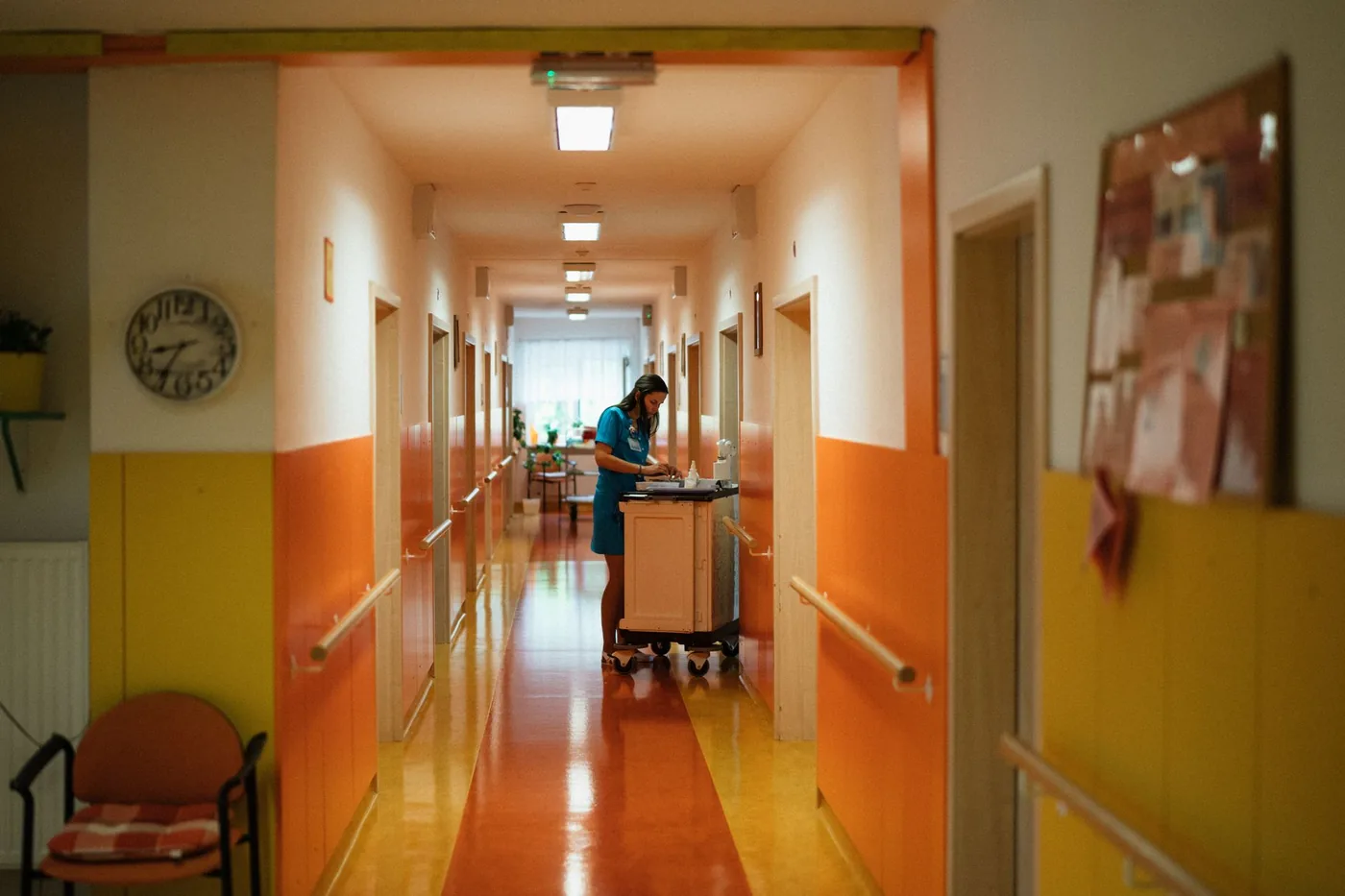 Nurse walking along a brightly painted hospital corridor