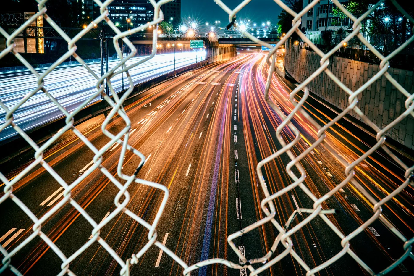 Vibrant long exposure of Atlanta highway showcasing dynamic nighttime traffic and city lights.