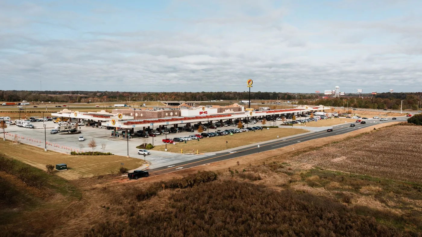 Aerial view of a large highway travel plaza and fuel canopy in Warner Robins, Georgia.