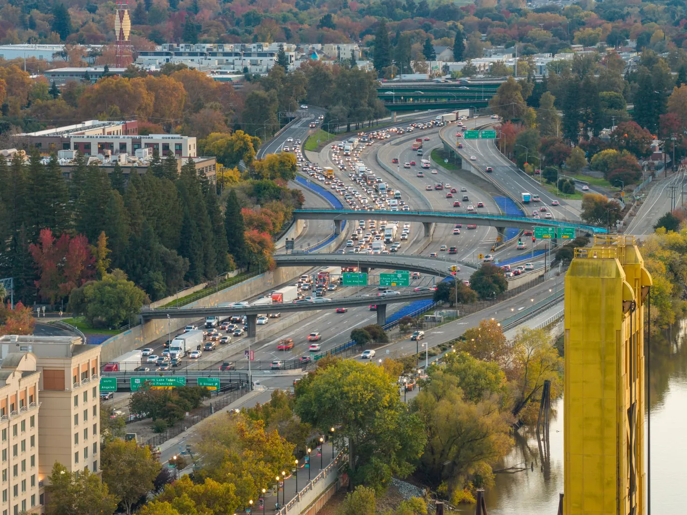 Aerial view of freeway traffic near Tower Bridge, Sacramento, showcasing fall foliage.
