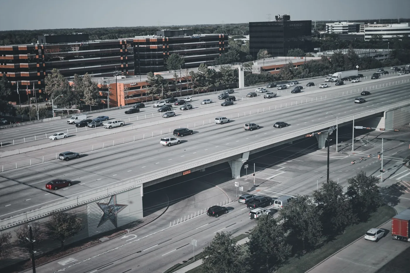 Aerial view of a busy urban highway with cars and trucks during the day.