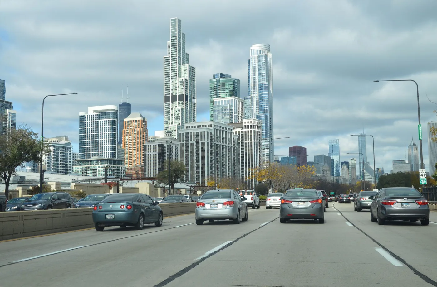 View of Chicago's skyline with dense traffic on a busy highway, showcasing iconic skyscrapers.