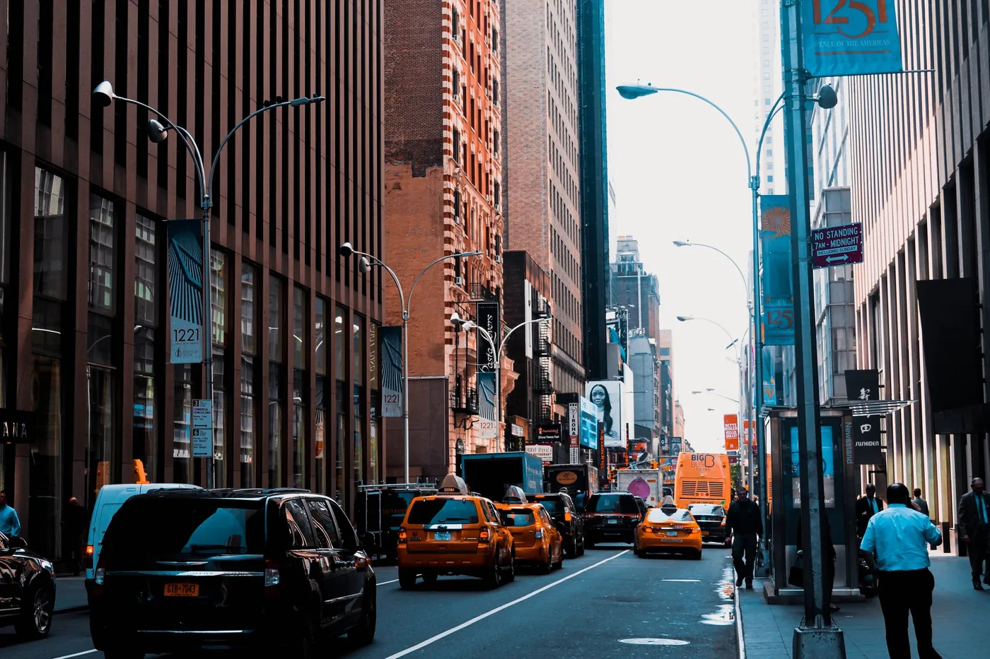 Vibrant city street in New York with taxis, tall buildings, and pedestrians.