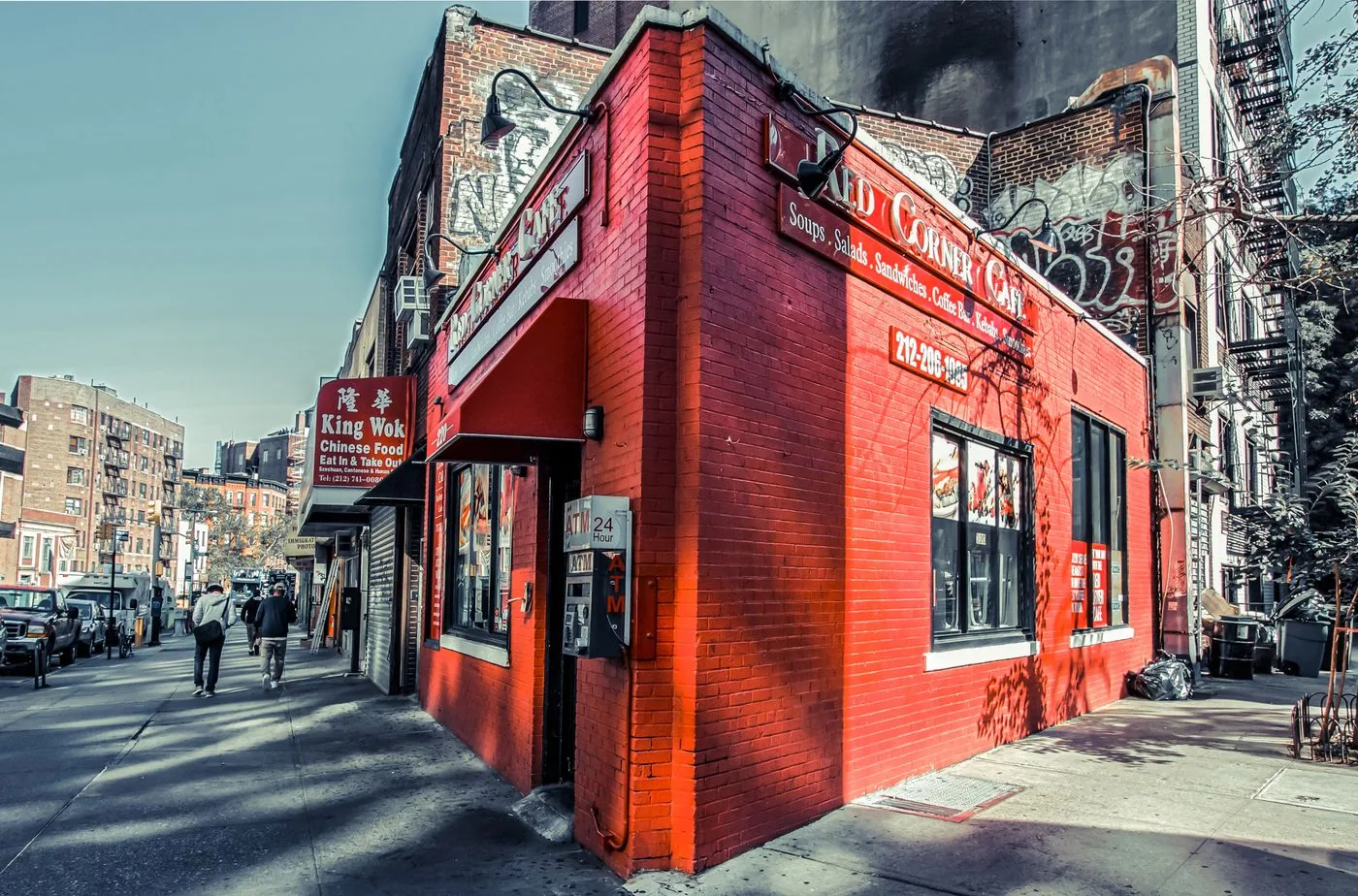 Bright red corner cafe on a busy New York City street.