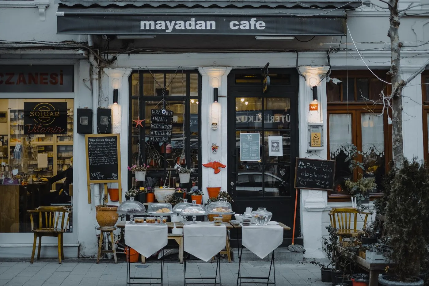 Sidewalk cafe display with menu boards and local food for sale.