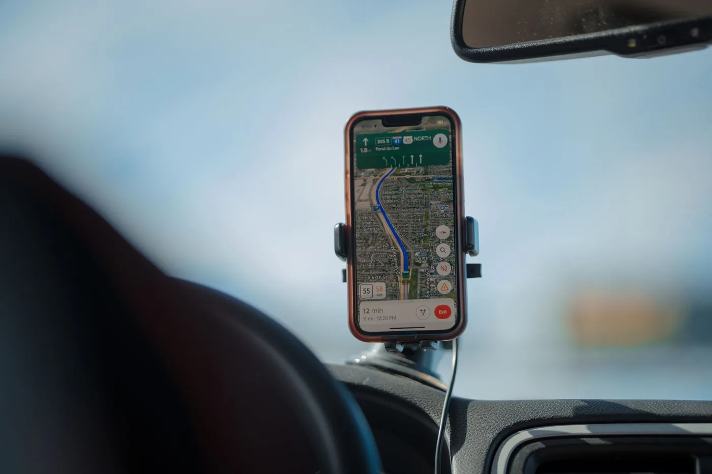 Smartphone with a GPS navigation map mounted on a car dashboard.