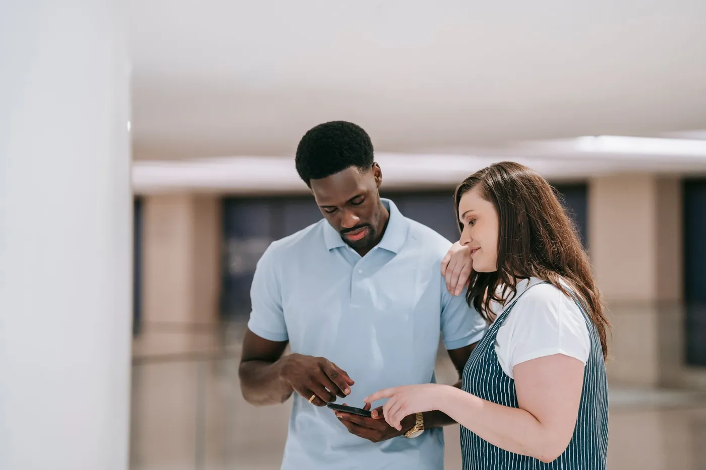 A couple looking at the screen of a mobile phone together.